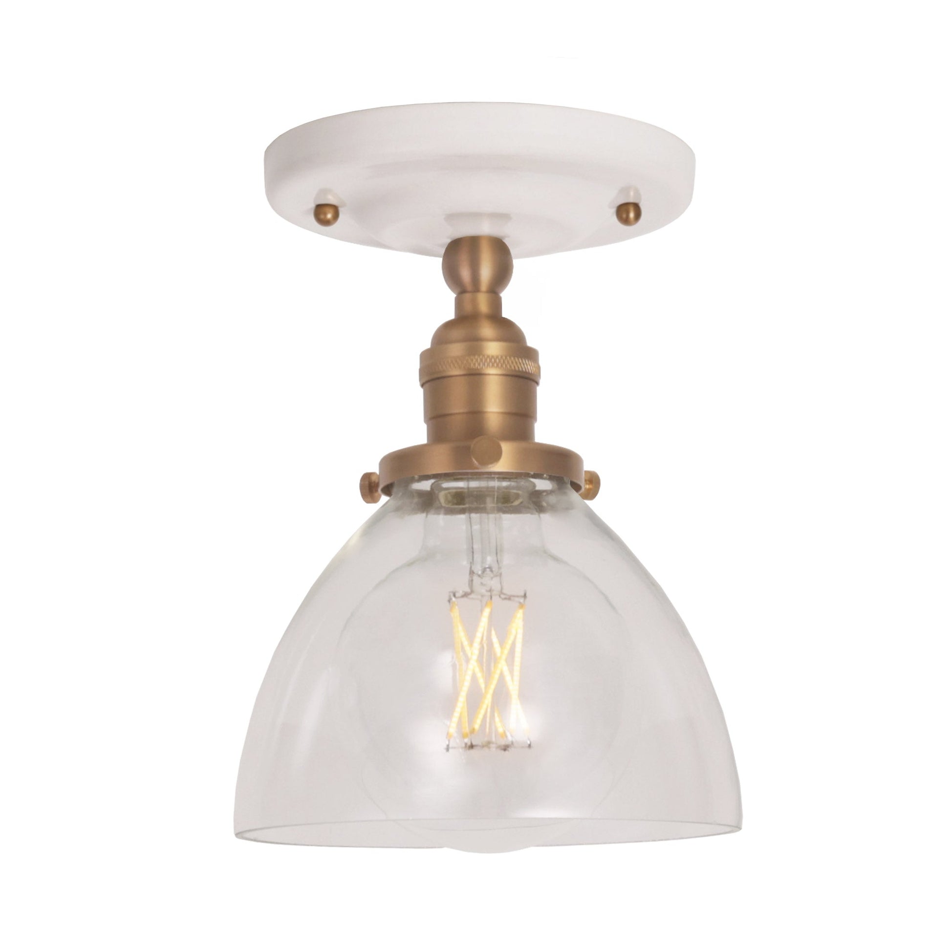 Grace Surface shown in Heirloom Brass with a Gloss White Ceramic canopy and Clear Glass shade